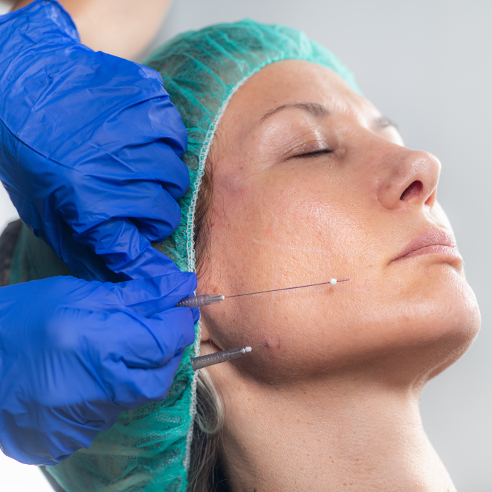 Mujer con los ojos cerrados, gorro ver de hospital y tranquila,se practica un tratamiento tensor de la piel 